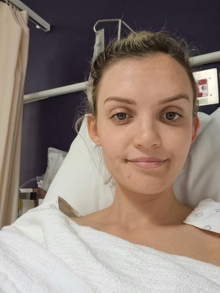 Close up of Ash sitting in a hospital bed